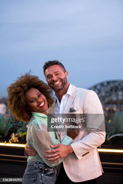 happy couple at a rooftop bar - glamour couple stock pictures, royalty-free photos & images
