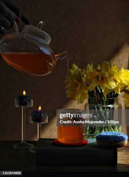 tea break,cropped hand pouring drink in glass on table - tea hot drink - fotografias e filmes do acervo