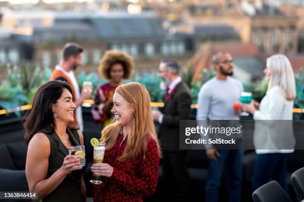enjoying cocktails at the rooftop party - rooftop party stock pictures, royalty-free photos & images