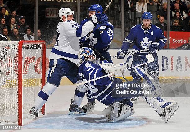 Jonas Gustavsson of the Toronto Maple Leafs is knocked over as teammate Carl Gunnarsson battles with Adam Hall of the Tampa Bay Lightning during NHL...