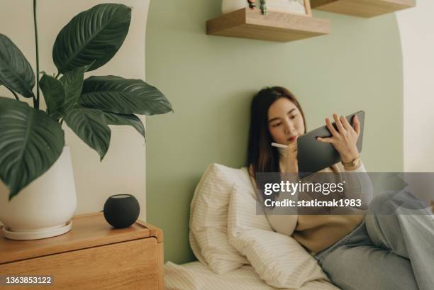 jovem fala com assistente de voz para controlar em casa - cg artist - fotografias e filmes do acervo