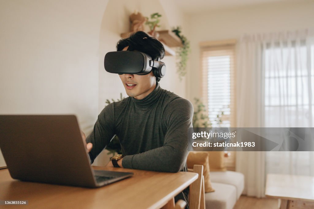 Junger Mann mit VR-Headset erkundet Virtual Reality
