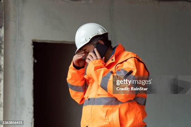 engineer talking by phone at construction site - stress stock pictures, royalty-free photos & images