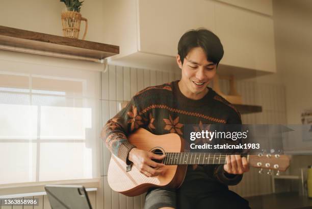 asian couple in kitchen having fun together. - asian musician stock pictures, royalty-free photos & images