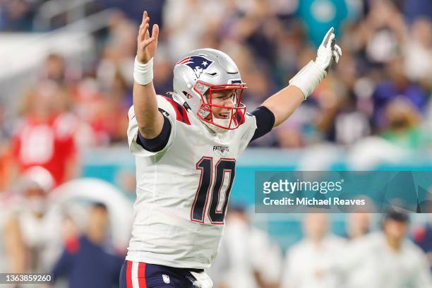 Mac Jones of the New England Patriots celebrates Damien Harris rushing for a touchdown in the fourth quarter of the game against the Miami Dolphins...