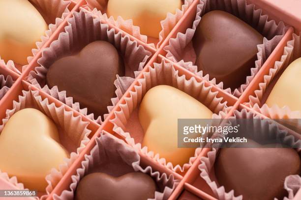 white and black chocolate in heart shape in pink box background. - chocolate box stock-fotos und bilder