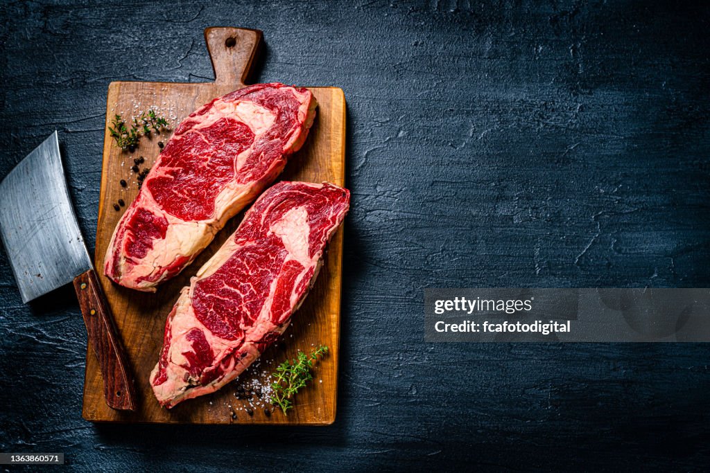 Raw beef steak fillets on dark table. Copy space