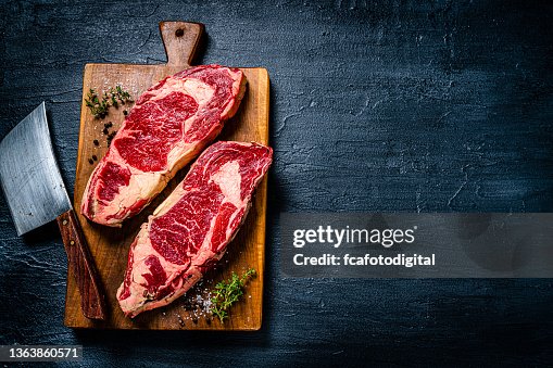Raw beef steak fillets on dark table. Copy space Raw beef steak fillets on dark table. Copy space