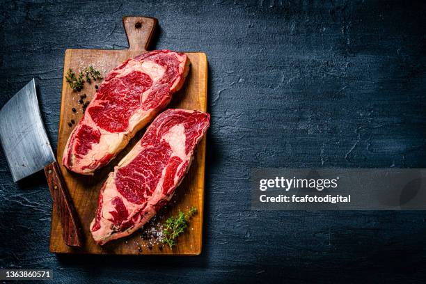 raw beef steak fillets on dark table. copy space - carnes imagens e fotografias de stock