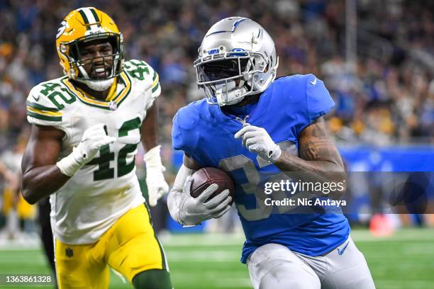 Andre Swift of the Detroit Lions runs the ball against Oren Burks of the Green Bay Packers to score a touchdown in the fourth quarter at Ford Field...