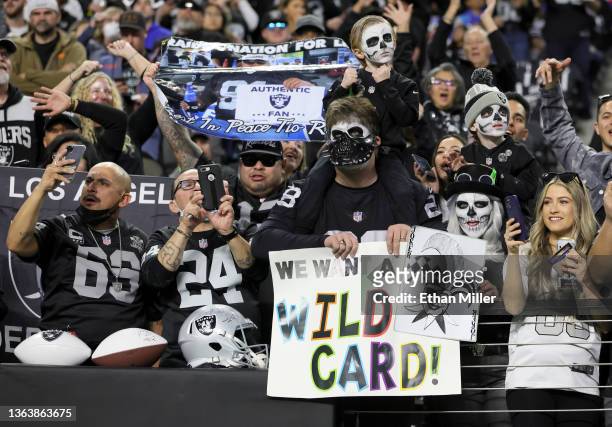 Las Vegas Raiders fans hold up signs before a game between the Raiders and the Los Angeles Chargers at Allegiant Stadium on January 9, 2022 in Las...