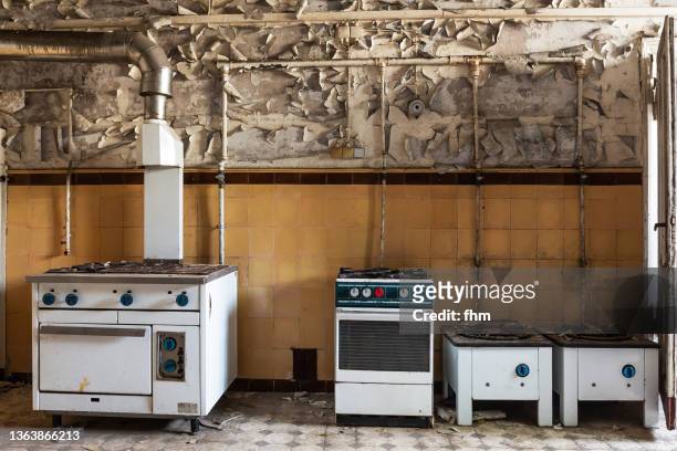 old kitchen in an abandoned building - broken appliance stock-fotos und bilder