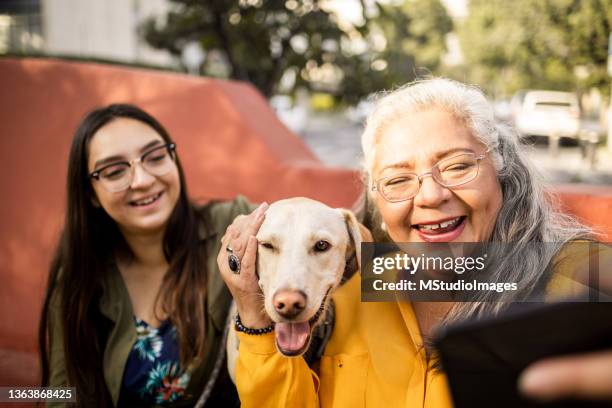 mother and daughter take selfie with dog - mexican mature women stock pictures, royalty-free photos & images