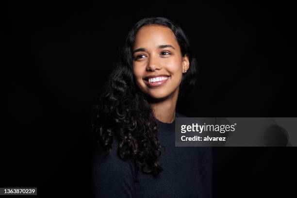 studio portrait of a happy latin american woman - zwarte achtergrond stockfoto's en -beelden