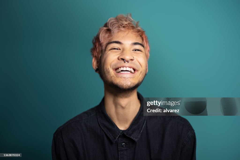 Cheerful young man smiling on blue background