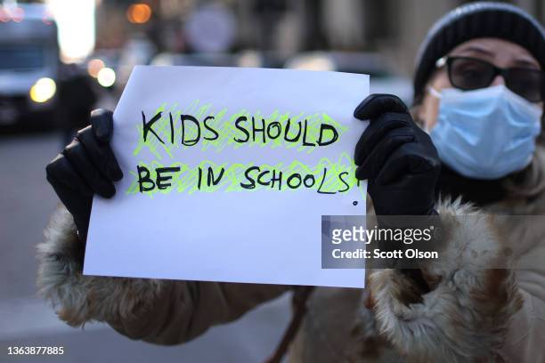 Counter-demonstrator holds up a sign as members of the Chicago Teachers Union and their supporters participate in a car caravan around City Hall to...