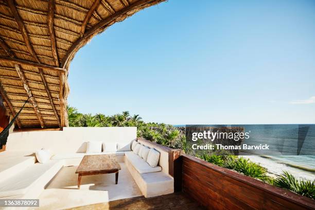 wide shot of sitting area on deck of luxury suite at tropical resort - lugar turístico fotografías e imágenes de stock