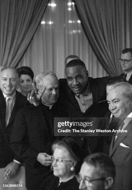 Photo shows Sonny Liston with his priest at the Sheraton Hotel in Chicago after winning the Heavyweight Title from Floyd Patterson by KO at 2:06 in...