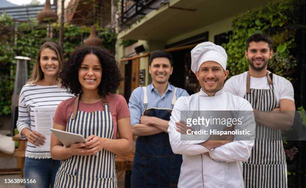 gruppe von food-service-arbeitern, die in einem restaurant lächeln - kellner stock-fotos und bilder