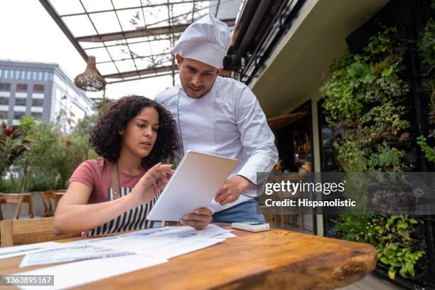 empresário fazendo os livros em um restaurante com a ajuda de seu chef - chef leader - fotografias e filmes do acervo