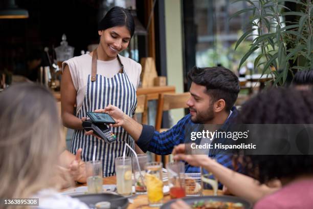 mann beim kontaktlosen bezahlen mit seinem handy in einem restaurant - pay restaurant stock-fotos und bilder