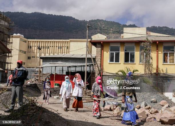 Doctors and construction workers walk between buildings during reconstruction at the Dessie Referral Hospital on January 10, 2022 in Dessie,...