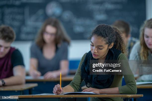 students writing at their desks in class - gymnasieexamen bildbanksfoton och bilder