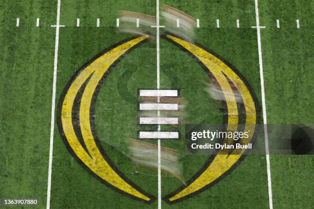 Players run across the 2022 CFP National Championship logo on the field in the first quarter of the game between the Georgia Bulldogs and the Alabama...