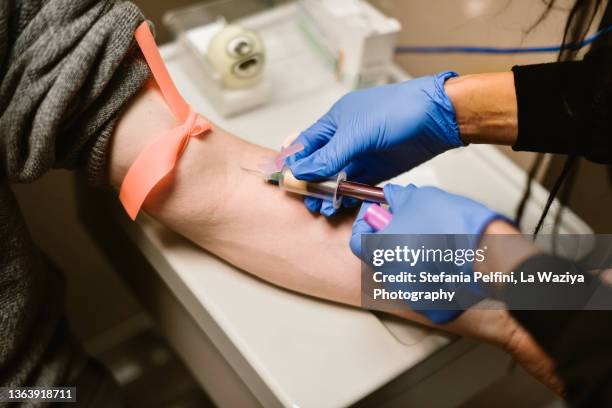 close up on nurse's hands while taking blood from patience. - bluttest stock-fotos und bilder