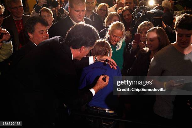 Republican presidential candidate, former Massachusetts Gov. Mitt Romney, signs a girl's t-shirt at the Hotel Fort Des Moines on the night of the...