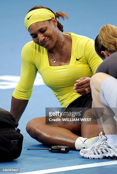 Serena Williams of the US receives treatment after injuring her ankle during her second round women's singles match against Bojana Jovanovski of...