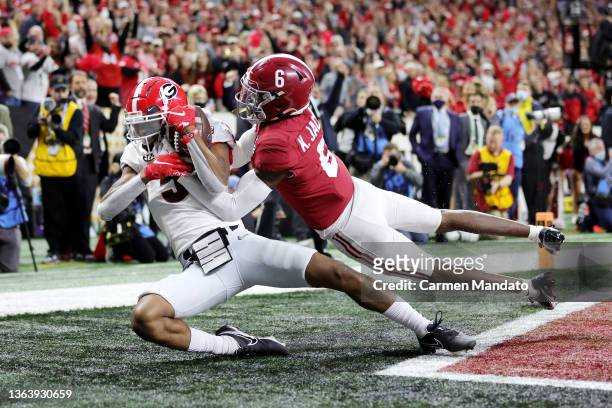 Adonai Mitchell of the Georgia Bulldogs catches the ball for a touchdown against Khyree Jackson of the Alabama Crimson Tide in the fourth quarter of...