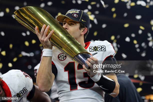 Stetson Bennett of the Georgia Bulldogs kisses the National Championship trophy after the Georgia Bulldogs defeated the Alabama Crimson Tide 33-18 in...