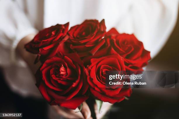 person giving bouquet of red roses. - rose ceremony stock pictures, royalty-free photos & images