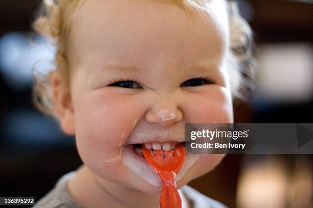 little girl eating yoghurt - smiling baby stock pictures, royalty-free photos & images