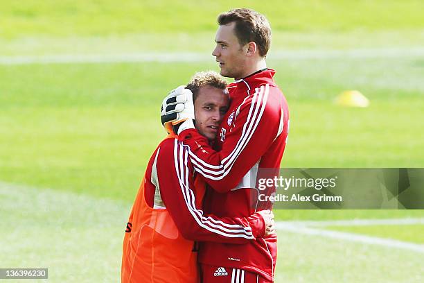 Goalkeeper Manuel Neuer hugs team mate Rafinha during a training session of Bayern Muenchen at the ASPIRE Academy for Sports Excellence on January 4,...