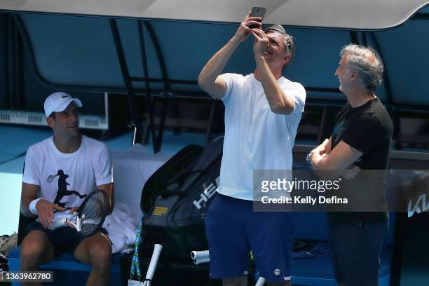 Novak Djokovic of Serbia watches Goran Ivanišević film news helicopters above during practice on Rod Laver Arena ahead of the 2022 Australian Open at...