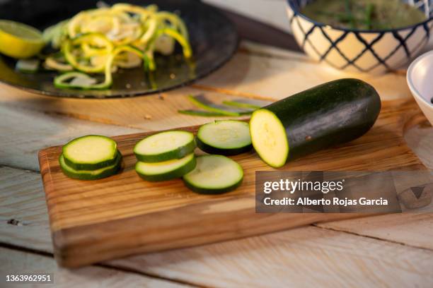 fresh zucchini on wooden cutting board - courgette stock pictures, royalty-free photos & images