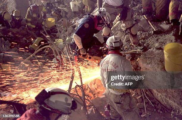 Rescue workers cut through the ruble with a saw 29 April 1995, in the Federal Building, Oklahoma City, looking for survivors from the 19 April...