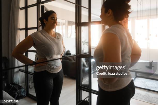 proudly looking at her own reflection - woman mirror stockfoto's en -beelden