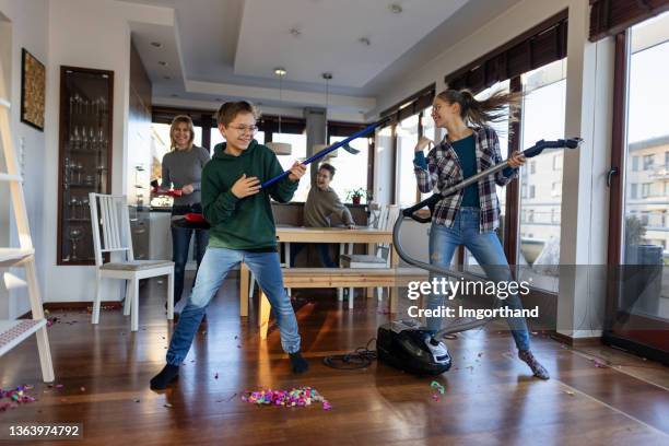 family cleaning the living room after party - cleaning after party stock pictures, royalty-free photos & images