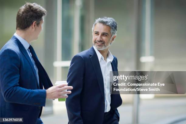 two businessmen walking and talking in city - grey suit stock pictures, royalty-free photos & images