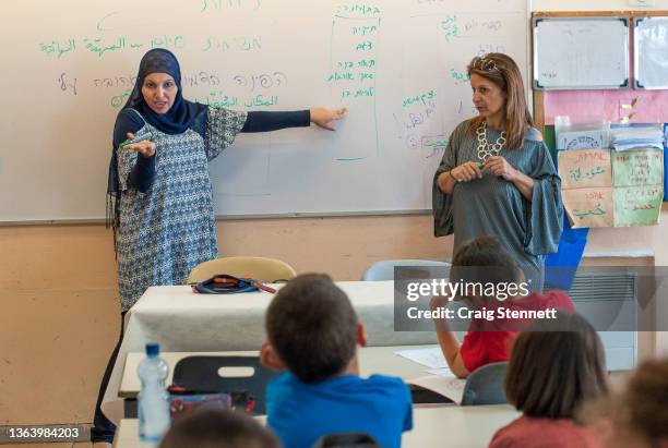 Teachers Alia Hussien and fellow teacher Efrat Toval give a lesson on identity to this class of 3rd Grade students simultaneously in Hebrew and...