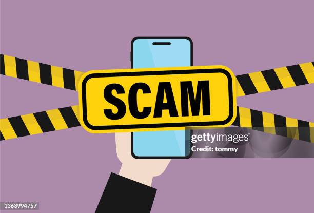 hand holds a mobile phone with a scam sign - corporate theft stock illustrations