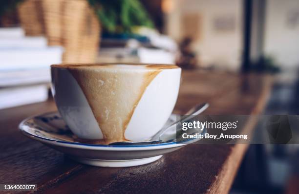 hot milk coffee overflow on the ceramic dish. - overflowing glass stockfoto's en -beelden