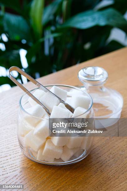 lump sugar in a transparent glass sugar bowl, on a wooden table or background, at home, in a cafe, cafeteria or restaurant. the concept of poor nutrition and lifestyle. - sugar bowl crockery stock pictures, royalty-free photos & images