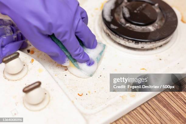 female hand in a glove washes the stove - dirty oven stock pictures, royalty-free photos & images