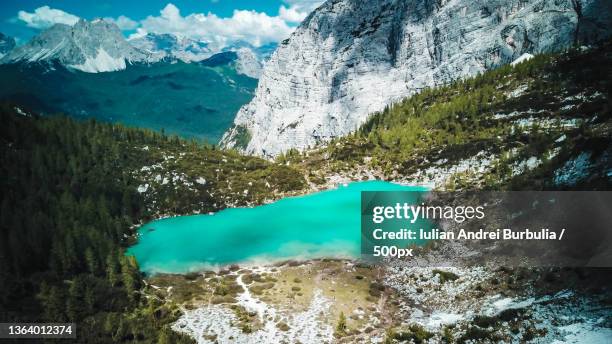 lake sorapis drone,scenic view of lake and mountains against blue sky,lake sorapis hike trailhead,italy - iulian andrei stock-fotos und bilder