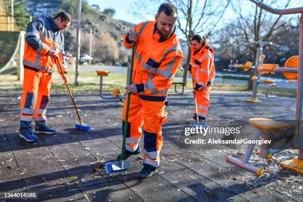 três trabalhadores de saneamento limpando academia ao ar livre de folhas e escombros - street sweeper - fotografias e filmes do acervo