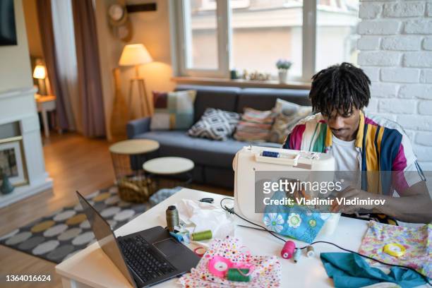 man busy sewing material on a machine - stitch stock pictures, royalty-free photos & images